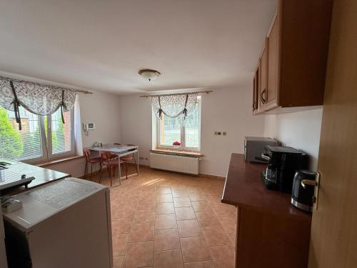a kitchen with a counter and a table in it at Dom Wczasowy Mateusz in Rewal