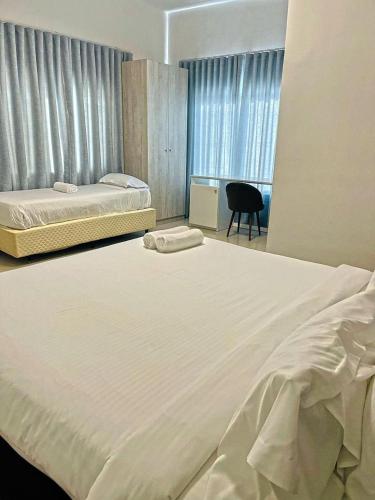 a bedroom with two beds and a desk and a chair at Decifer Sport Resort in Belas