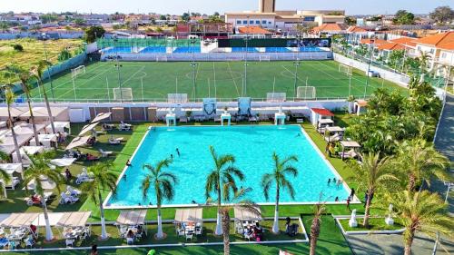 an overhead view of a large swimming pool with palm trees at Decifer Sport Resort in Belas