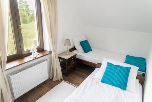 a small room with two beds and a window at Galikowo in Płaska