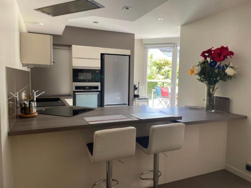 une cuisine avec un comptoir et deux tabourets dans l'établissement Bel appartement avec terrasse, à Saint-Grégoire