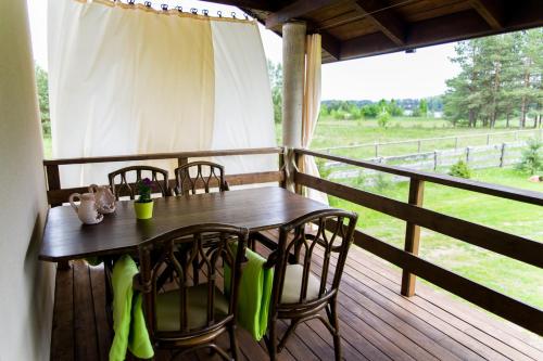 a table and chairs on a porch with a view of a field at Galikowo in Płaska