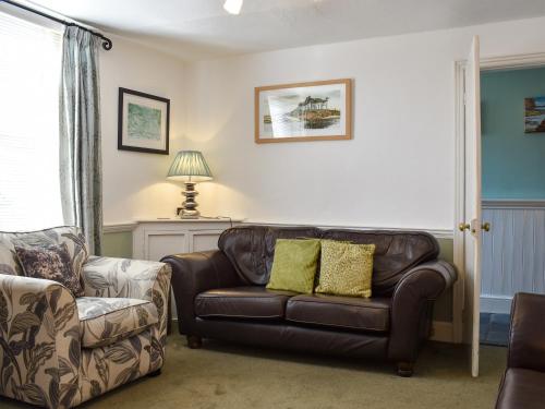 ein Wohnzimmer mit einer Couch und einem Sessel in der Unterkunft Old Town Cottage in Sidmouth