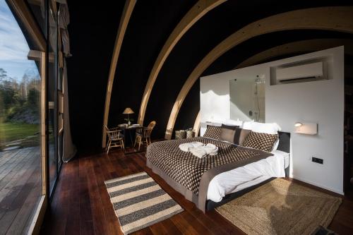 a bedroom with a bed and a large window at Room8 luxury glamping in Huldenberg
