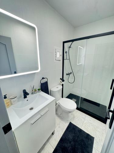 a white bathroom with a shower and a toilet at Casa Salamanca La Mata in Torrevieja