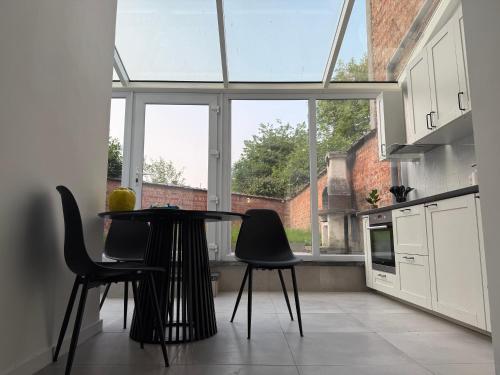 cocina con mesa y sillas frente a una ventana en Oasis Apartament, en Bruselas