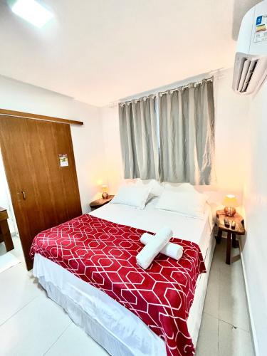 a bedroom with a large bed with a red blanket at Pousada Tô na Praia Juquehy in Juquei
