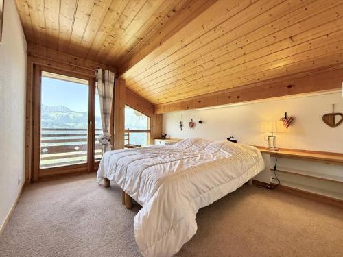 - une chambre avec un grand lit dans une pièce dotée d'une fenêtre dans l'établissement Chalet Cristal - Chalet de charme avec sauna et superbe vue sur le MOnt Charvin et les Aravis MAE-1154, à Crest-Voland
