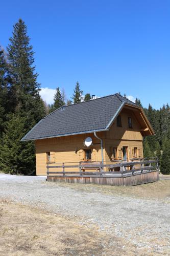 a large wooden cabin with a black roof at Hüttentraum Flattnitz in Flattnitz