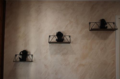 a wall with three black cats sitting on shelves at Maison privative SPA Jacuzzi Sauna Salle de jeux in Weitbruch