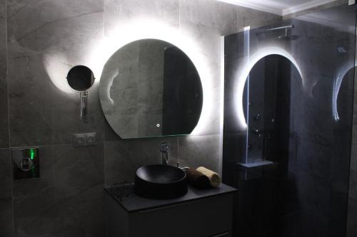 a bathroom with a sink and a mirror at Maison privative SPA Jacuzzi Sauna Salle de jeux in Weitbruch