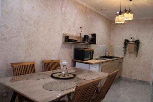 a kitchen with a wooden table with chairs and a kitchen with a microwave at Maison privative SPA Jacuzzi Sauna Salle de jeux in Weitbruch