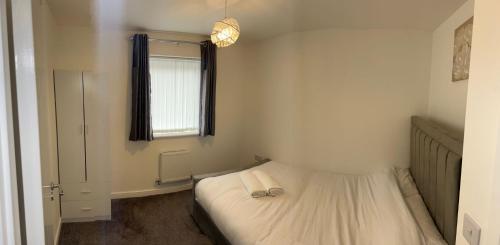 a small bedroom with a bed and a window at Tranquility Home in Greenhithe