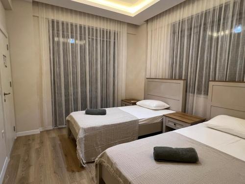ein Hotelzimmer mit drei Betten und einem Fenster in der Unterkunft Serentha Villas 2 in Belek