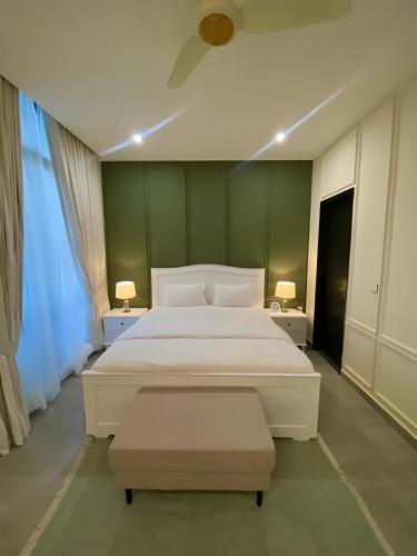 a bedroom with a large white bed and two lamps at Elysium Retreat Facing Centaurus Mall Islamabaad in Islamabad