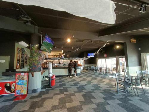 a restaurant with tables and chairs in a room at Mobil Home 3ch CONFORT Camping 4étoiles Les Charmettes 393 Proche FUN ZONE in Les Mathes