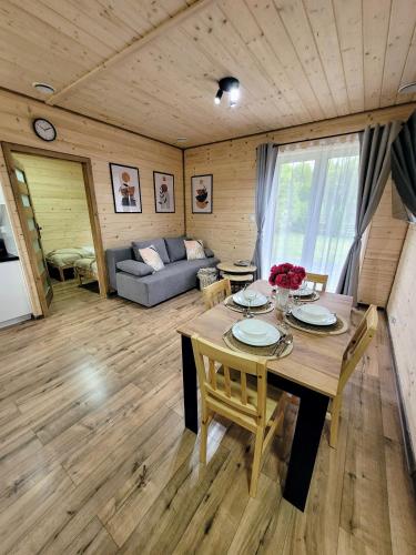 a living room with a wooden table and a couch at Roztoczańska Kryjówka in AdamÃ³w