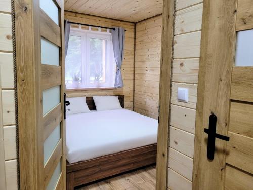a small room with two beds and a window at Roztoczańska Kryjówka in AdamÃ³w