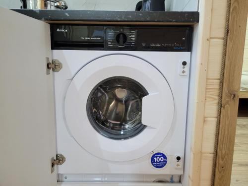 a white washing machine in a cabinet at Roztoczańska Kryjówka in AdamÃ³w