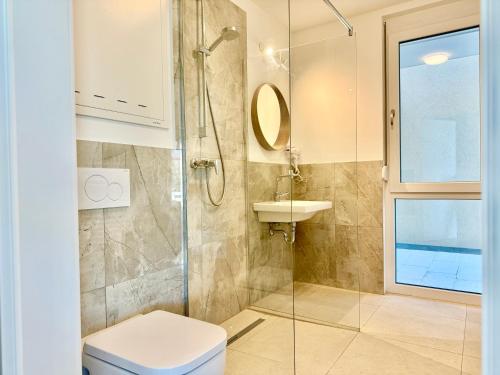 a bathroom with a shower and a toilet and a sink at Modern Apartment with Balcony near SCS in Wiener Neudorf