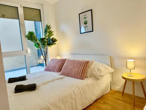 a bedroom with a white bed with a vase at Modern Apartment with Balcony near SCS in Wiener Neudorf