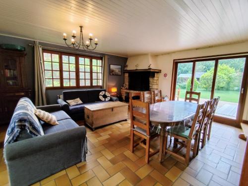 un salon avec une table et un canapé dans l'établissement Chaumière La Huchette, à Quend