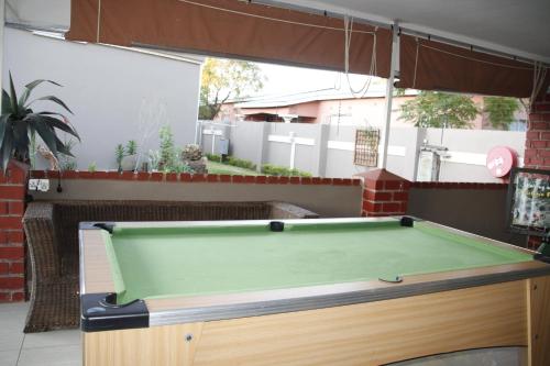 a pool table in a backyard with at Asante Apartments in Livingstone