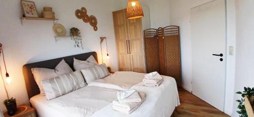 a bedroom with a white bed with towels on it at Strandperle Timmel in Großefehn 
