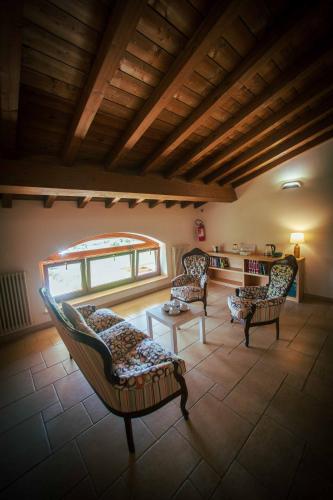 a living room with chairs and a table and a window at Casale Elisa Country Hotel in Ladispoli