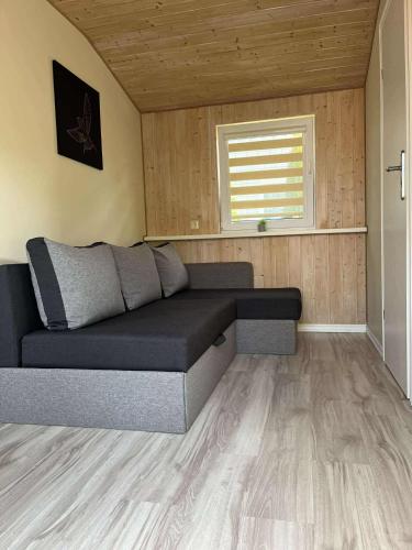 a couch in a living room with a window at Namelis ,,Gilė” in Šventoji