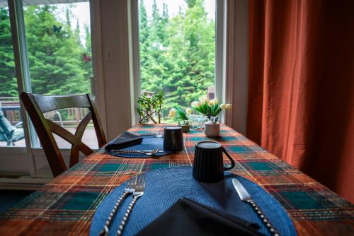 a table with a table cloth on it with a window at Gîte Crystal Inn in Mont-Tremblant