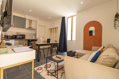 un salon avec un canapé et une cuisine dans l'établissement KasbahBoHome, Expérience d'ailleurs, centre ville de Nîmes, à Nîmes