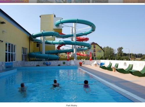personas en una piscina con tobogán de agua en Sunset Apartments Kropla Baltyku, en Darłówko