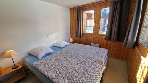 a bedroom with a bed and a window at Pra Charris - La Forclaz - Appartement in La Forclaz