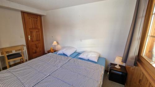 a small bedroom with a bed and a window at Pra Charris - La Forclaz - Appartement in La Forclaz