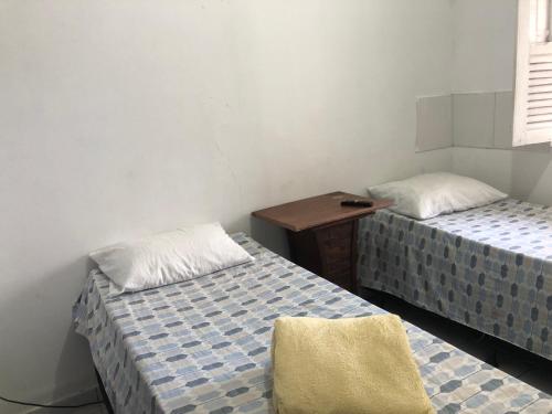 a room with two beds and a wooden table at Hostel e Pousada Sr Borba in Recife