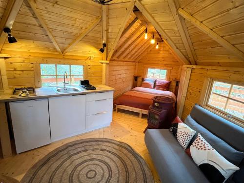 a kitchen and living room of a log cabin at Aux Étangs de Jourgnac - Kota in Jourgnac