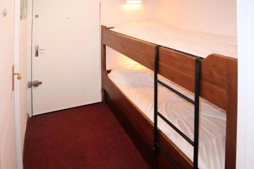 Ce lit superposé se trouve dans un dortoir doté d'une porte. dans l'établissement Résidence Les Carlines - LES CARLINES - Studio 4 Pers. Vue Pistes MAE-6491, aux Orres