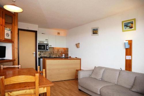 un salon avec un canapé et une cuisine dans l'établissement Résidence Le Cairn - studio 10ème étage le cairn MAE-6581, aux Orres