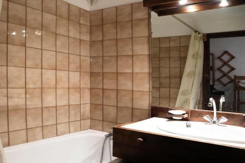 une salle de bain avec une baignoire et un lavabo et une baignoire dans l'établissement Résidence Le Cairn - studio 10ème étage le cairn MAE-6581, aux Orres
