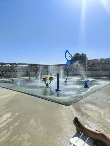 une personne assise sur un banc devant une fontaine dans l'établissement Résidence Caraibes - Appartement 2 pièces au 1er étage à LE BARCARES - CAP COUDALERE MAE-8334, au Barcarès