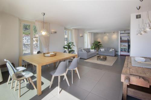 a living room with a wooden table and chairs at Architect s house in Dongo