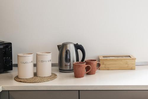 a counter with three coffee cups and a kettle at Architect s house in Dongo