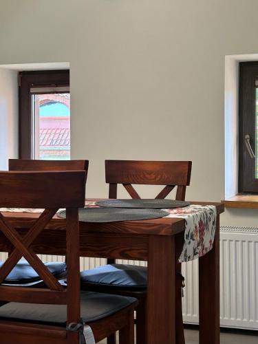 a dining room table with two chairs and a window at Mazurska Zagroda - Żabi Rechot - dom - stodoła - jacuzi-sauna in Worliny