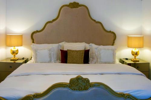 a bedroom with a large bed with two lamps at Casalinho da Azenha - Charm House in Sintra