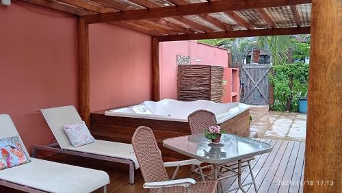 a patio with a tub and chairs and a table at Pousada Oceano e Mar in Ilhabela