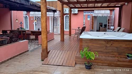 a hot tub on a wooden deck with a restaurant at Pousada Oceano e Mar in Ilhabela