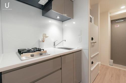 a white kitchen with a sink and a stove at n'estate 横浜阪東橋 in Yokohama
