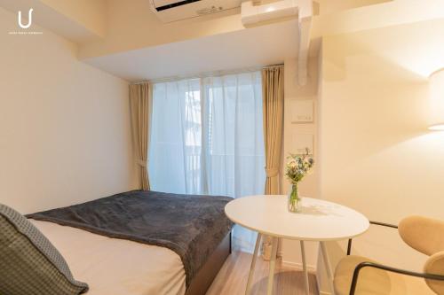 a small room with a bed and a table at n'estate 横浜阪東橋 in Yokohama