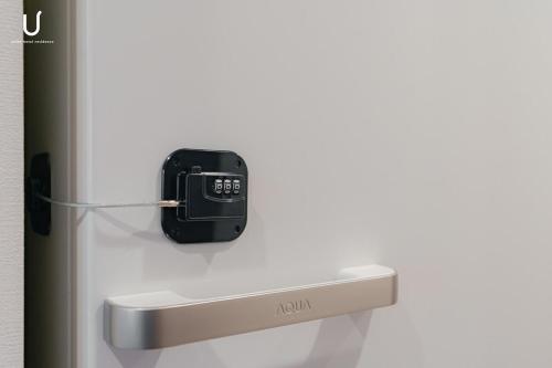 a cell phone hanging on the side of a refrigerator at n'estate 横浜阪東橋 in Yokohama